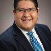 Portrait of Joaquin Rodriguez-Lopez on a tan background