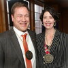 Two people standing side by side with medals around their necks