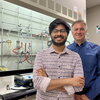 Shounak Nath and Liviu Mirica stand together in front equipment in a chemistry lab