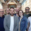 Group of researchers stand side by side in atrium of Beckman Institute.