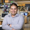 Angad Mehta standing in a lab with arms crossed in front of him