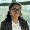 Head shot of Viviana Palacio-Betancur standing in front of a wall of glass windows