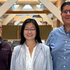 Three people standing side by side in the Beckman atrium