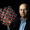 Omar Yaghi holding a molecular structure model on a dark background
