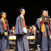 Graduates walking on stage in graduation regalia