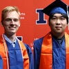 Strand and Yang in graduation regalia on an orange Block I background 