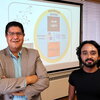 Joaquin Rodriguez-Lopez and Riyo Das standing in front of an overhead screen.