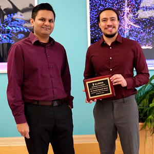 Professor Prashant Jain, left, and Dr. Daniel Dumett Torres. Torres is holding his Physical Chemistry Dissertation Award plaque.