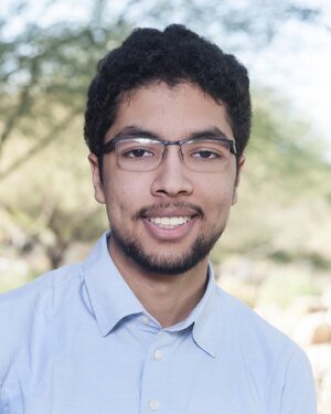 Head shot of Omar Alshangiti in a collared shirt with trees in the background 