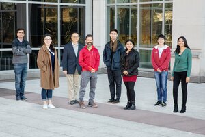 Photo of UIUC research team standing outdoors in front of a building on campus 
