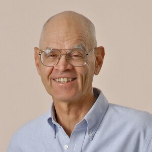 Head shot of Prof. Peter Beak in light blue button-down collared shirt on a gray background