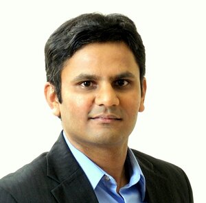 Head shot of Prashant Jain in a suit coat and light blue collared shirt on a white background