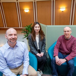 Charles Schroeder, student researcher, Caroline Li, and Jeffrey Moore sit on chairs at the Beckman Institute. 