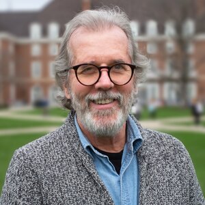 Head shot of Ralph Nuzzon outdoors on the UIUC campus with the Quad and buildings in the background