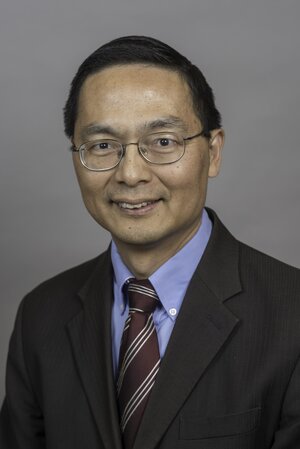 Head shot of Huimin Zhao on a gray background.
