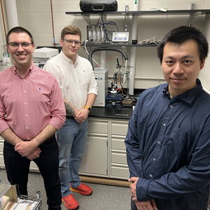 Three postdoctoral researchers stand in the lab where the study was conducted.
