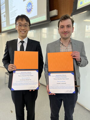 Daniel Hu and Joe Lastowski stand side by side holding award certificates in front of them.
