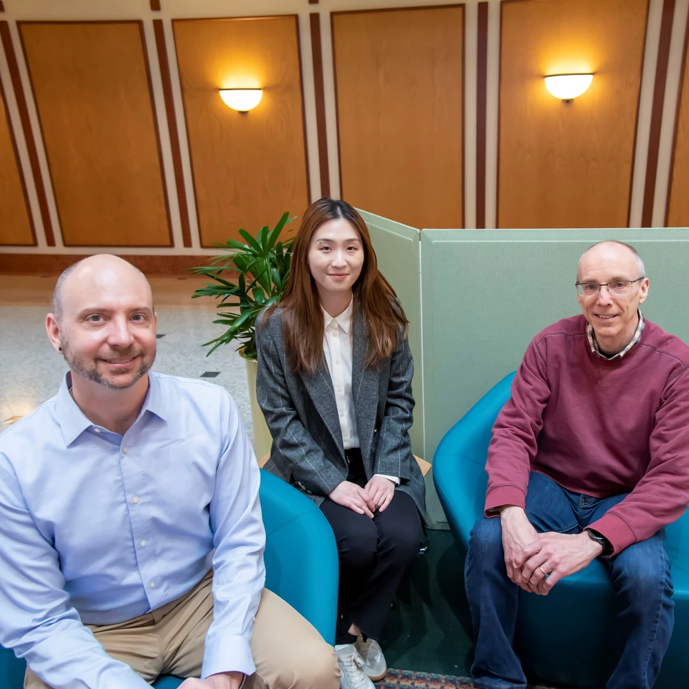 Charles Schroeder, student researcher, Caroline Li, and Jeffrey Moore sit on chairs at the Beckman Institute.