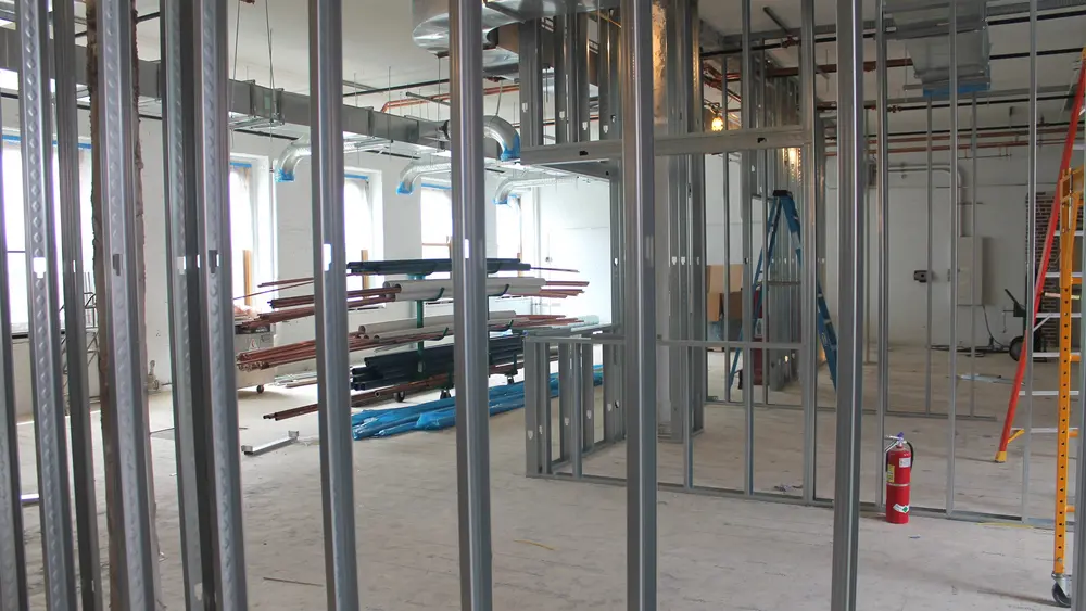 Steel frames of walls and other construction materials in a large open space under construction in Noyes Lab.