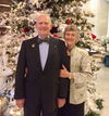 Photo of Bill Walters standing next to Barbara Walters with a holiday tree in the background.
