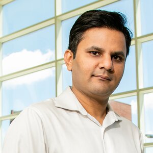 Portrait of Prashant Jain with a wall of windows in background.