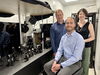 Stephan Link, Stephen Lee, and Christy Landes are pictured in the lab next standing and sitting next to equipment used in their research. 