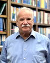 Head shot of Scott Denmark in front of a wall of books on a bookshelf