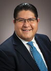 Portrait of Joaquin Rodriguez-Lopez on a tan background