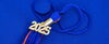 Tassel from a graduation cap laying on top of a blue graduation cap