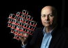 Omar Yaghi holding a molecular structure model on a dark background