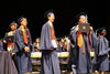 Graduates walking on stage in graduation regalia