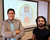 Joaquin Rodriguez-Lopez and Riyo Das standing in front of an overhead screen.