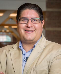 Head and shoulders photo of Joaquin Rodriguez Lopez smiling, looking into the camera wearing a sport coat and button-down shirt