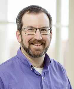 Head shot of Josh Vura-Weis on a light background inside a building.