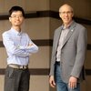 Researchers Yue Liu and Jeffrey Moore stand side by side in front of a concrete wall on campus. 