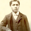 Two tone portrait of Carlos Montezuma in a suit sitting with one arm leaning on a table.