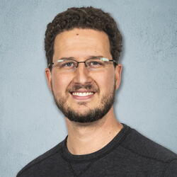 Head shot of Christian Ray on a light blue background