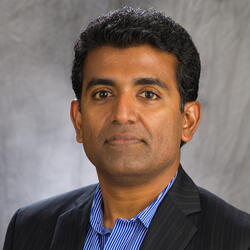 head shot of Gunasekera on a gray background